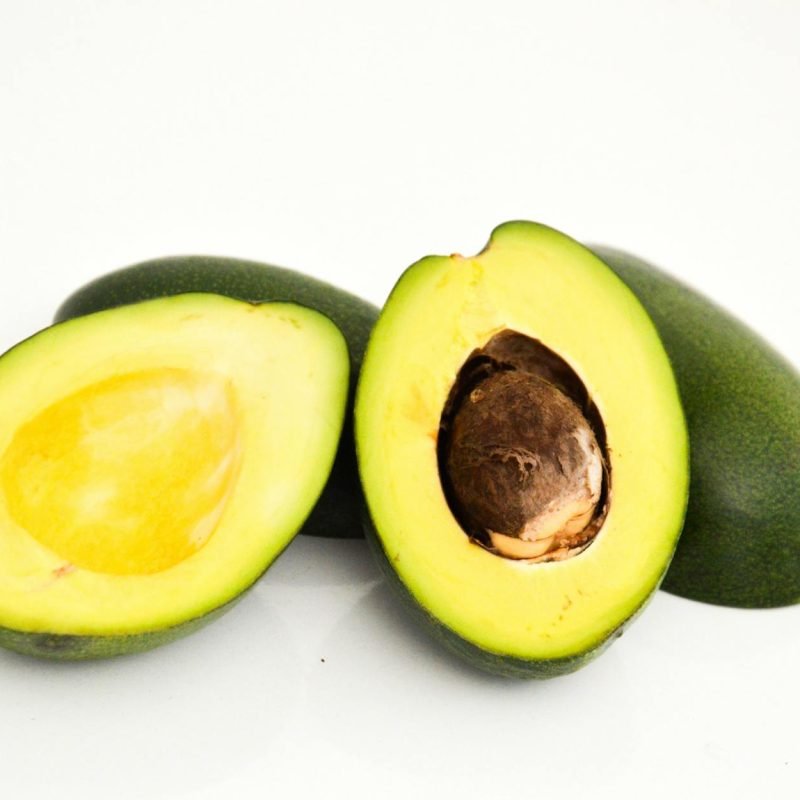 Close-up of fresh avocado halves showcasing vibrant green flesh and seed.